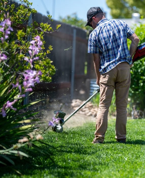 a man using a lawn mower to cut grass